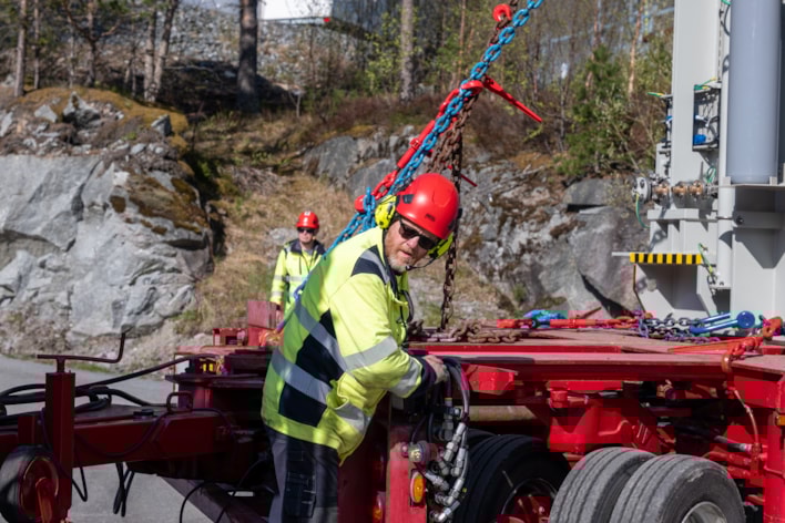 Mann med hjelm arbeider på transport